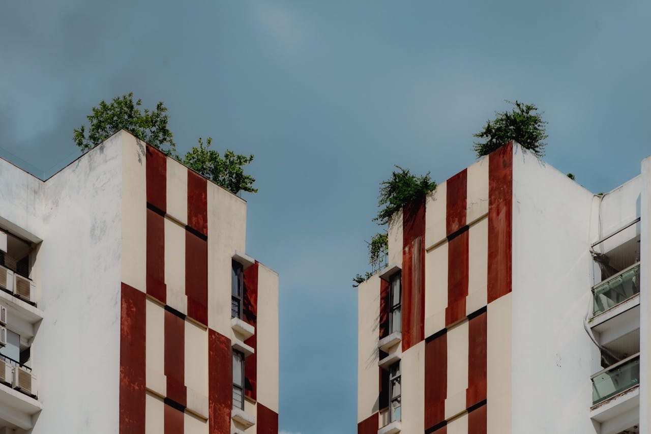 Contemporary city apartment buildings with green rooftop gardens against a clear sky.